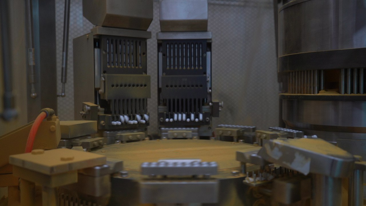 Industrial capsule filling machine line inside a supplement manufacturing facility to improve capsule filler output